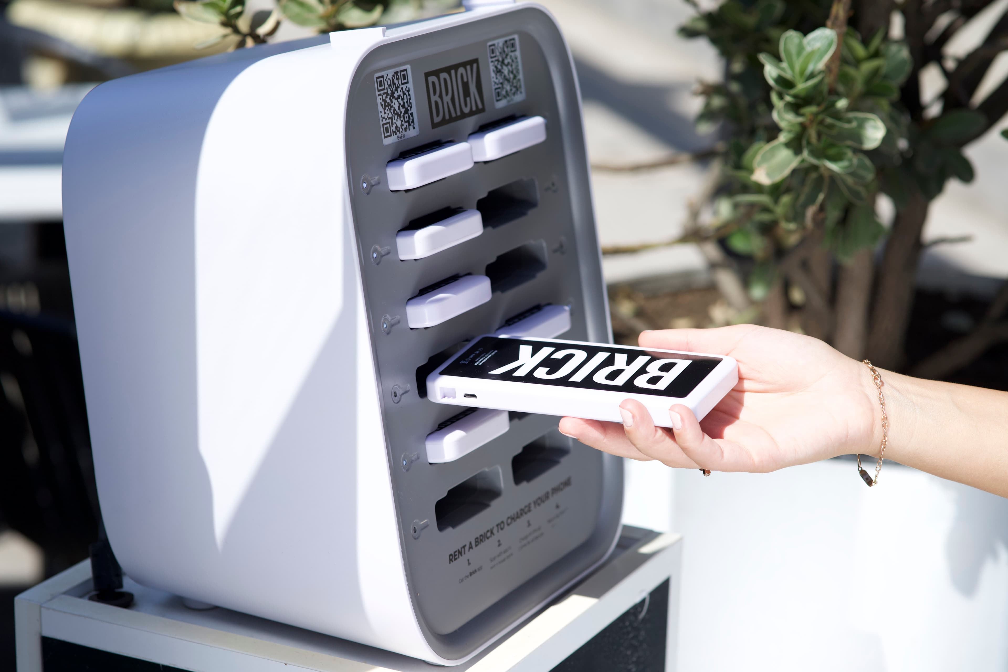 Ręka wkładająca Brick power bank do stacji